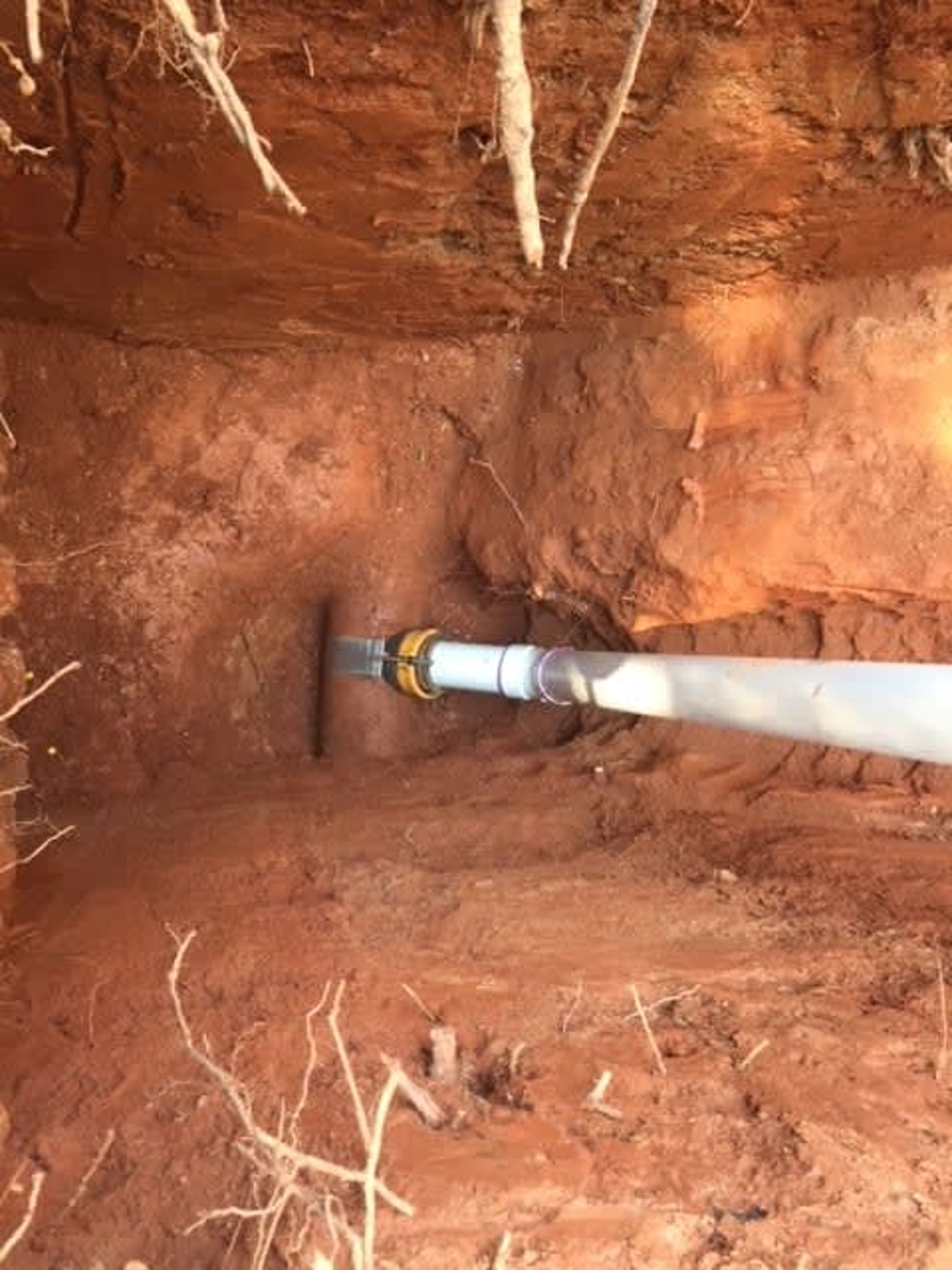 A pipe is being installed in a hole in the ground.