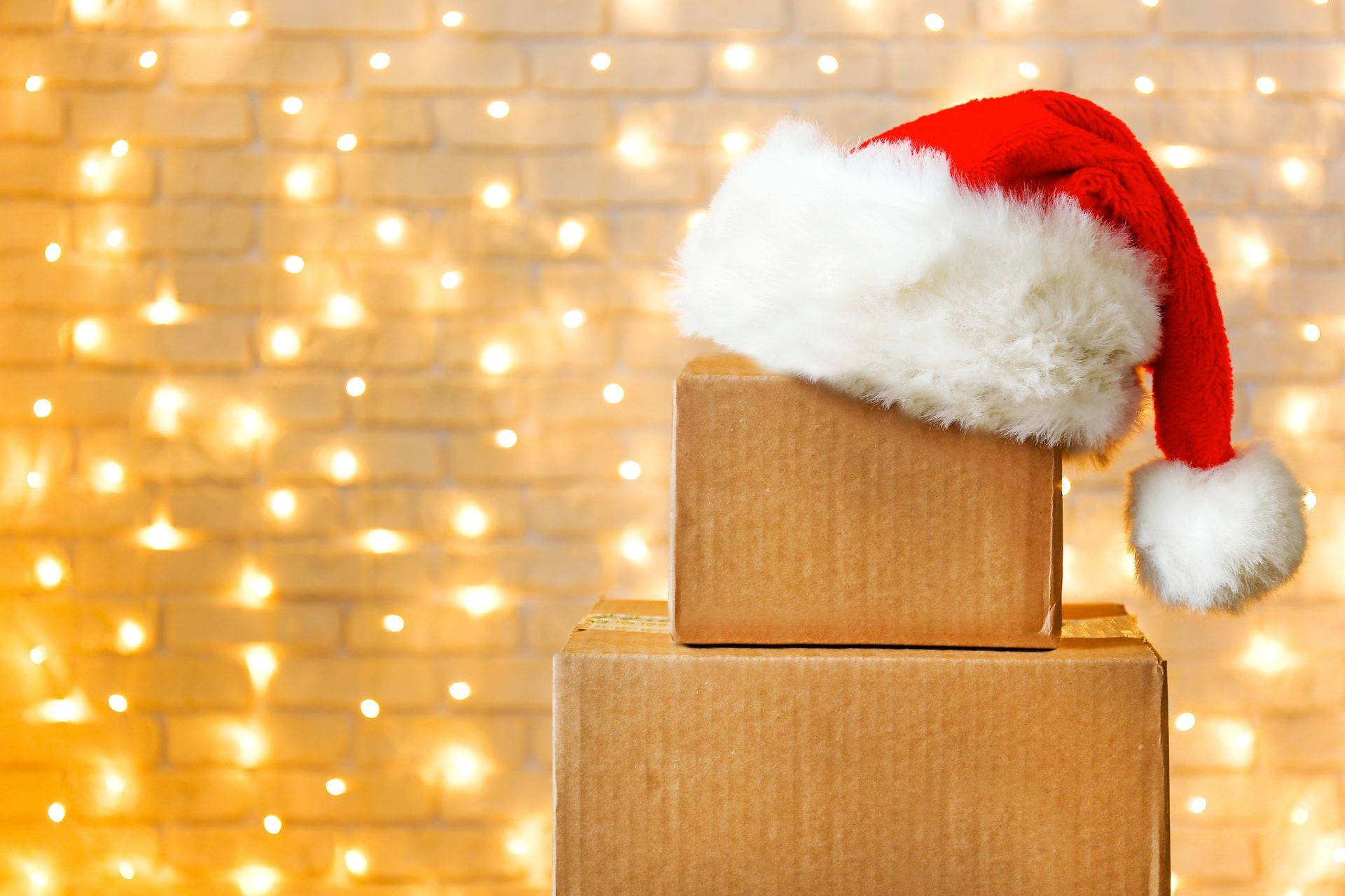 A stack of cardboard boxes with a santa hat on top of them.