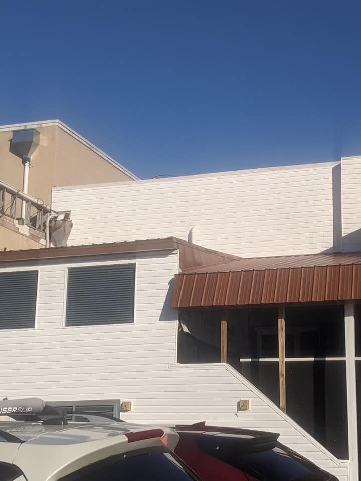 A white car is parked in front of a building