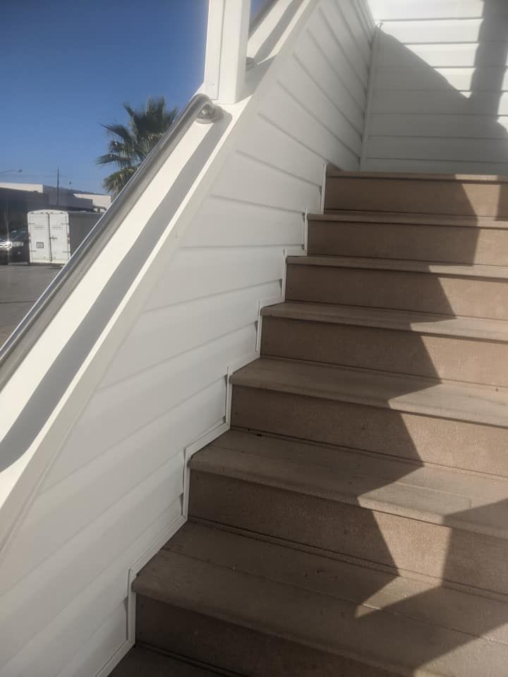 A set of stairs leading up to a building with a white railing.