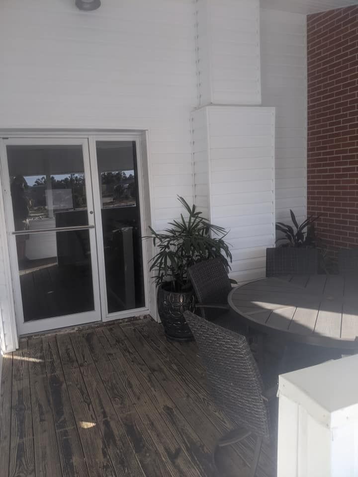 A patio with a table , chairs , and a potted plant.