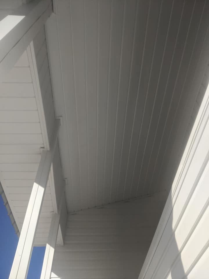 The ceiling of a white house with a blue sky in the background.
