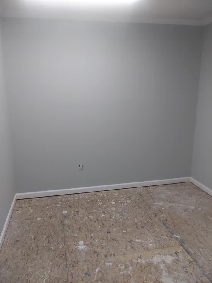 An empty room with a wooden floor and white walls.