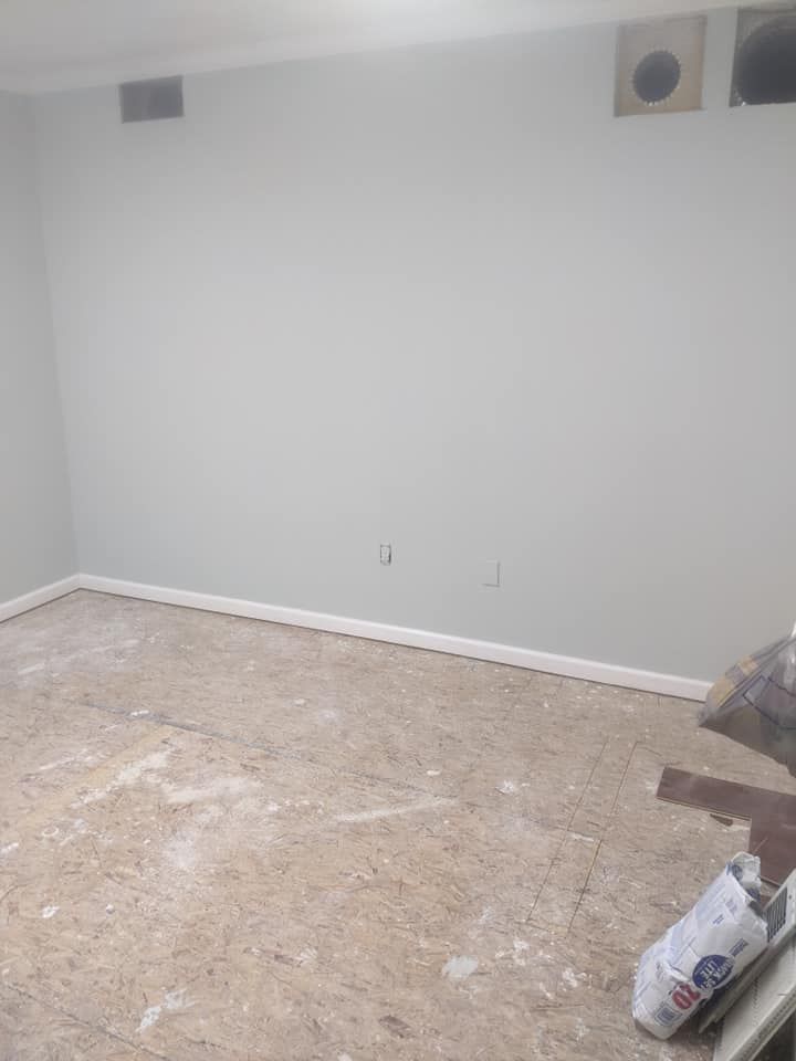 An empty room with a carpeted floor and white walls.