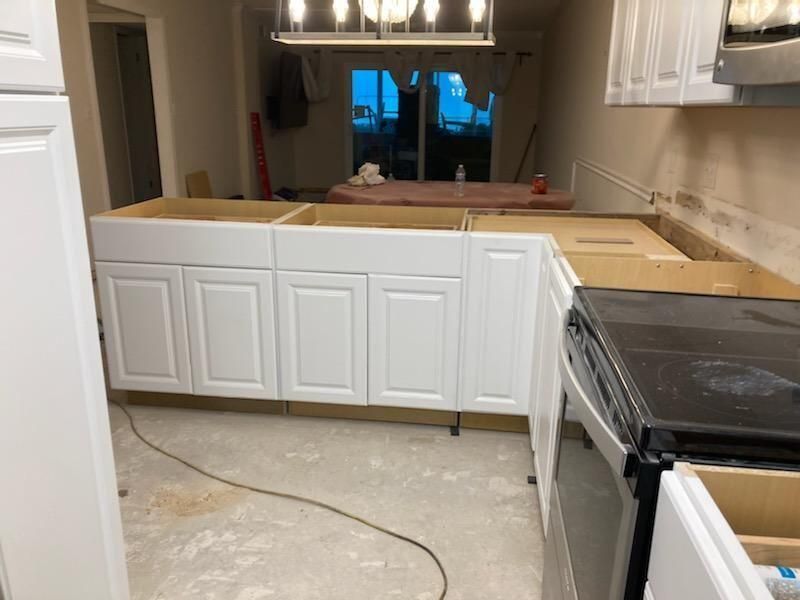 A kitchen with white cabinets and a black stove top oven