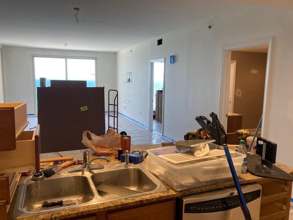 A kitchen under construction with a sink and a dishwasher.