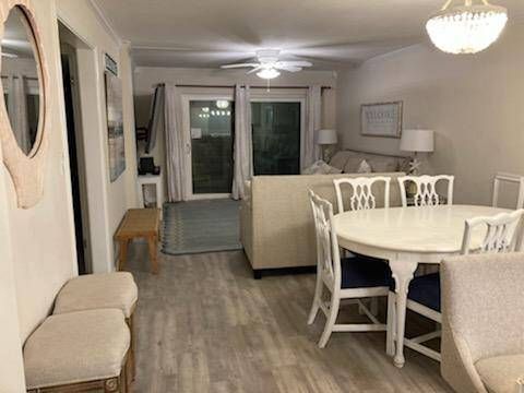 A living room with a table and chairs and a ceiling fan.