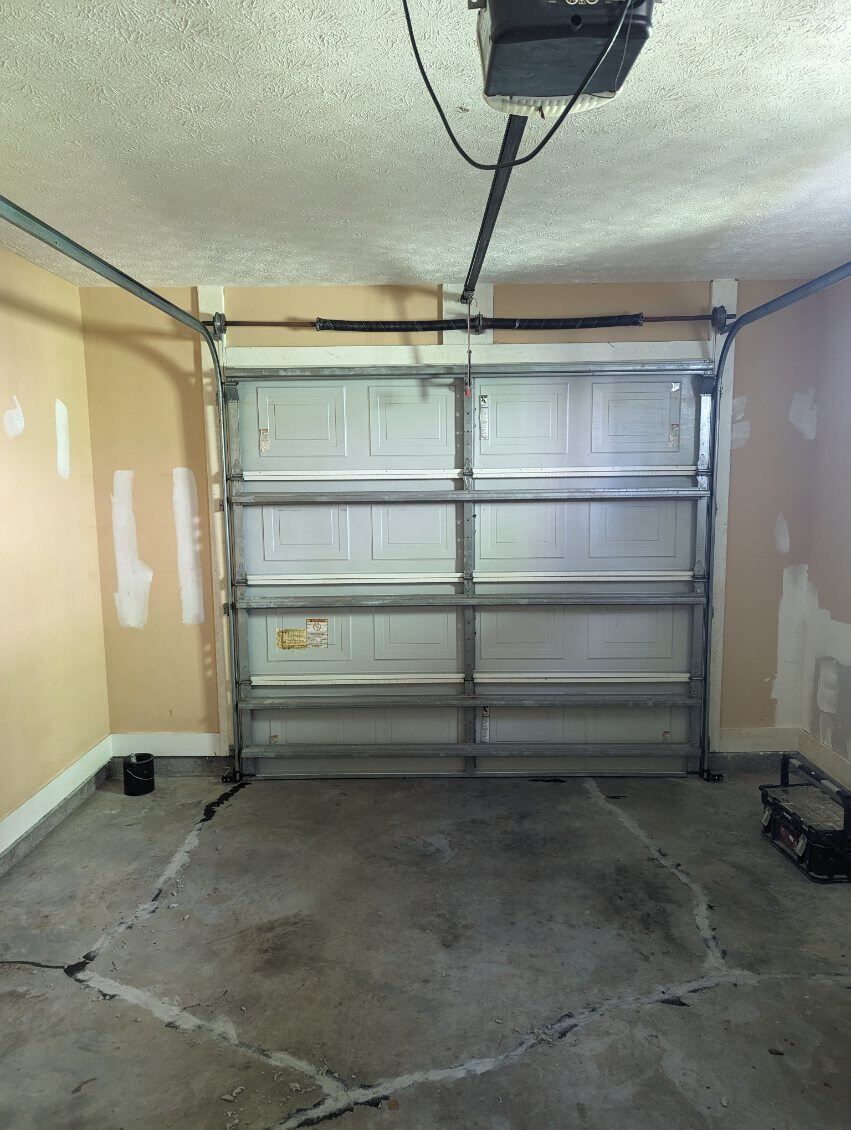 A garage with a garage door open and a garage door opener.