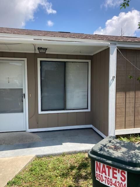 A house with a trash can that says nate 's on it