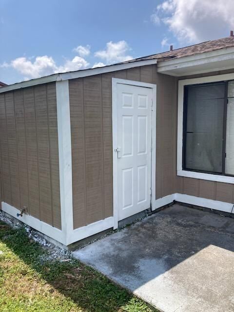 A brown house with a white door and a window.