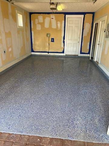 An empty garage with a concrete floor and a door.