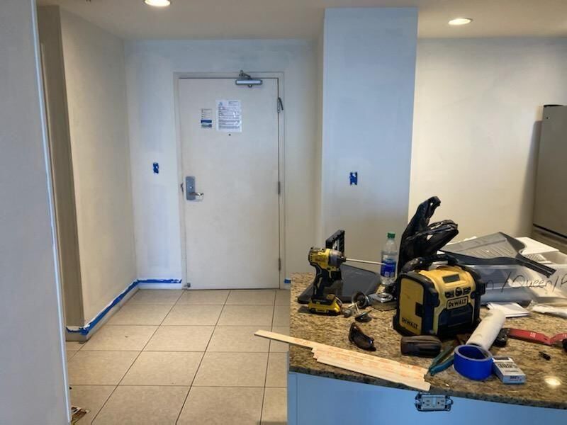 A room with a door and a counter with tools on it.