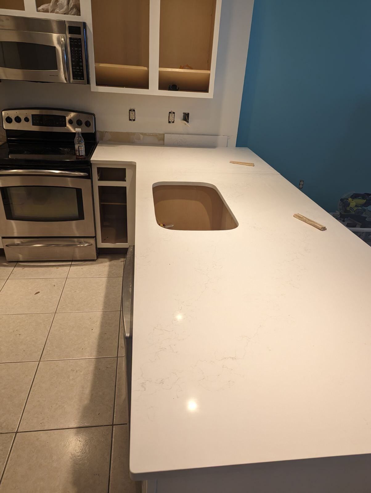 A kitchen with a white counter top and a sink