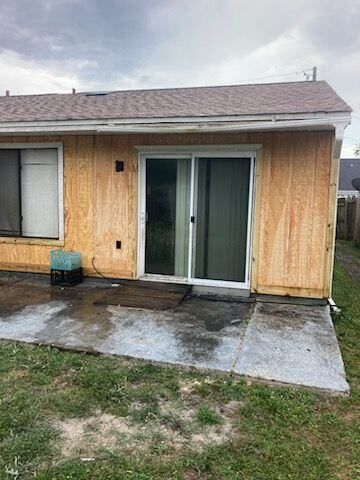 A house with a sliding glass door and a concrete patio.