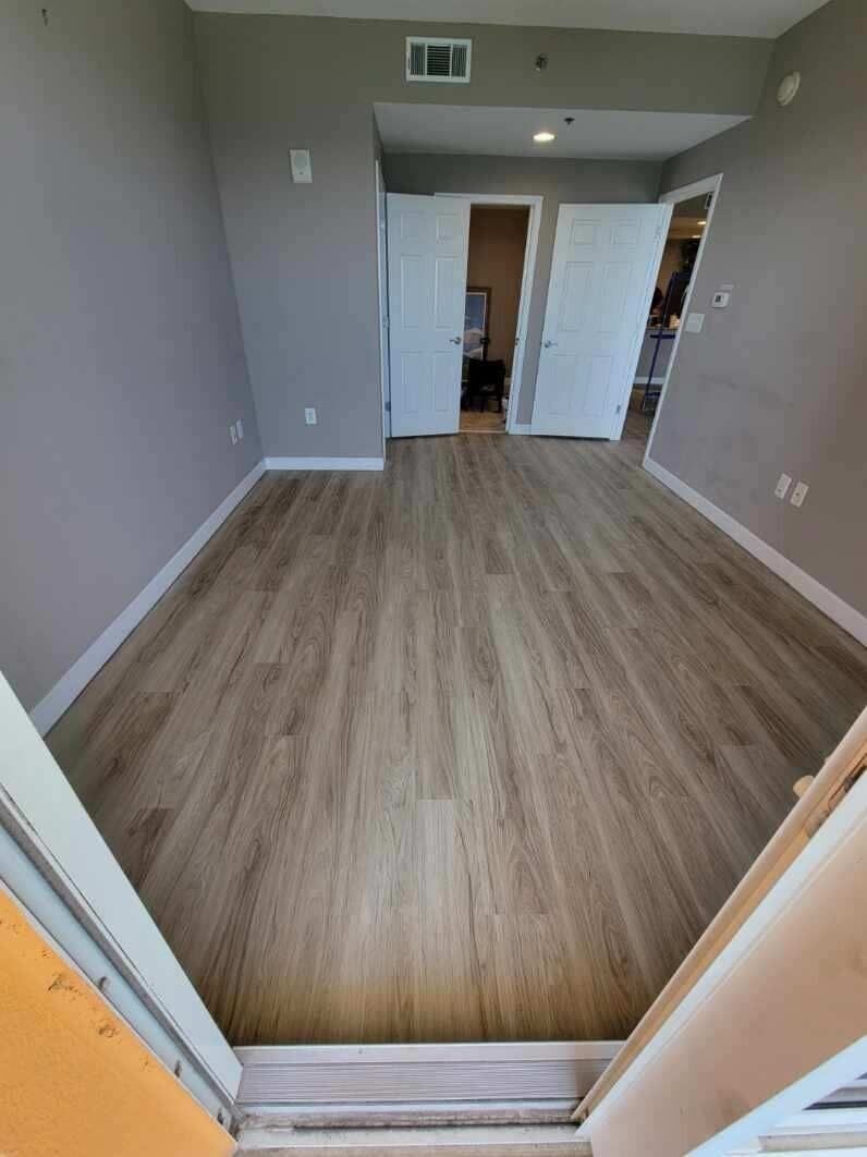 An empty room with hardwood floors and white doors