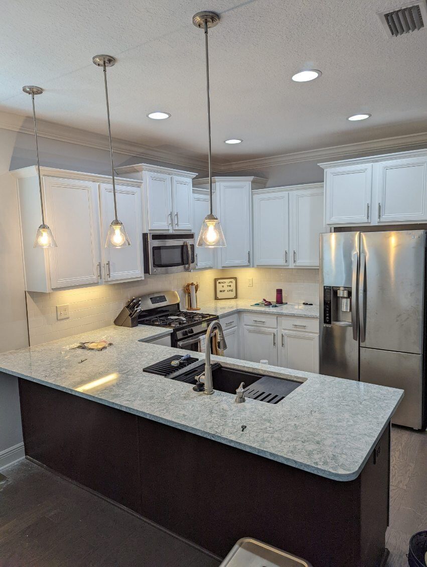 A kitchen with white cabinets and stainless steel appliances