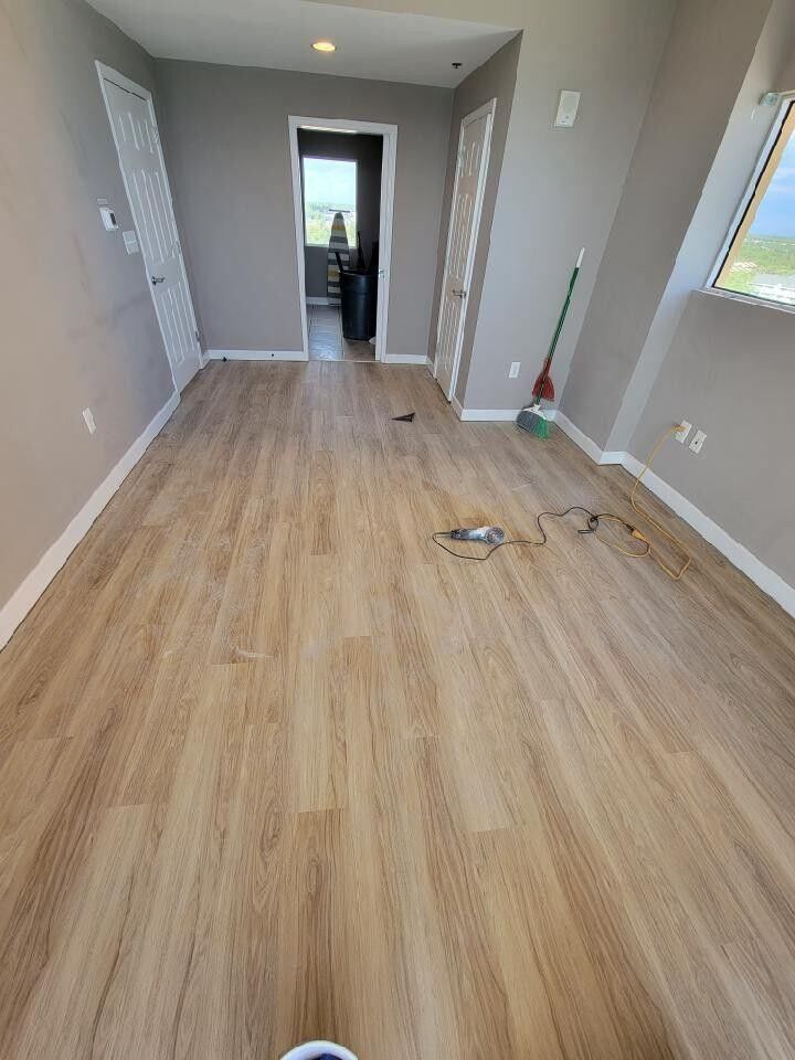 A room with hardwood floors and a broom in it.