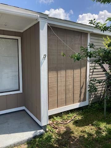 A mobile home with a window and a tree in front of it.