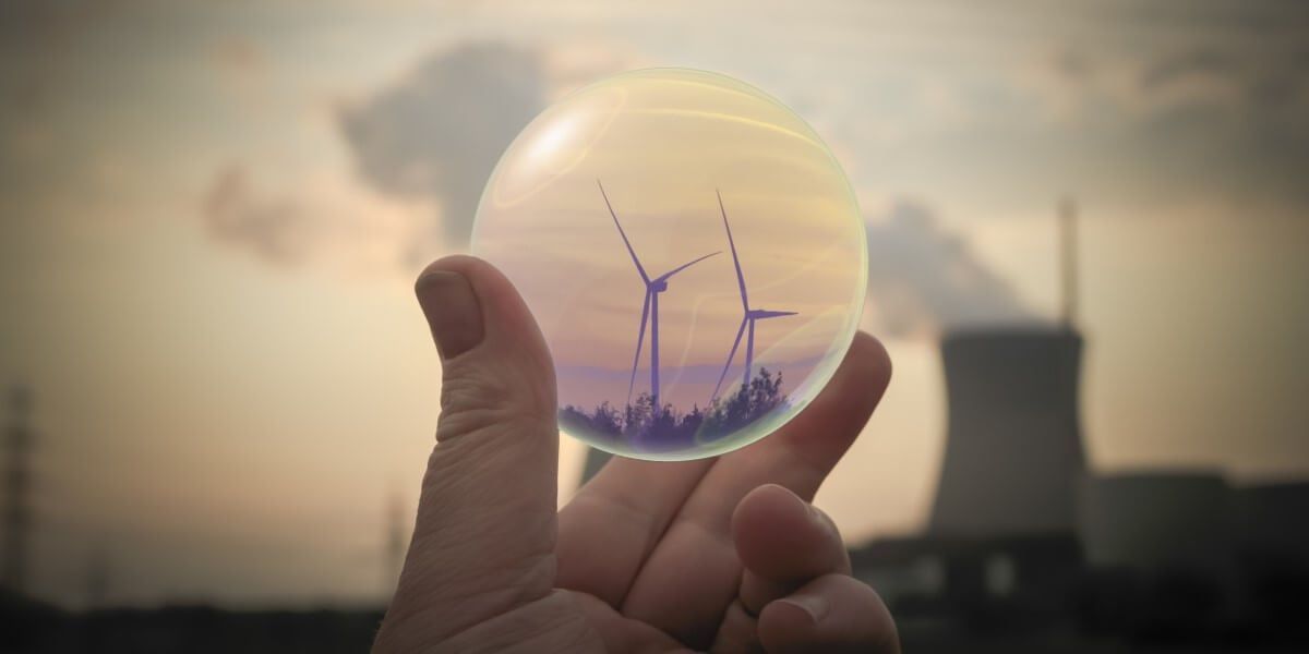 Uma pessoa está segurando uma bola de vidro com turbinas eólicas dentro.