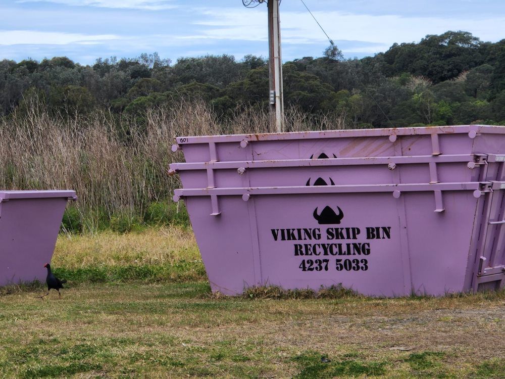 Purple Viking Skip Bins For Recycling, In A Grassy Field — Viking Skip Bin Recycling In Dunmore, NSW
