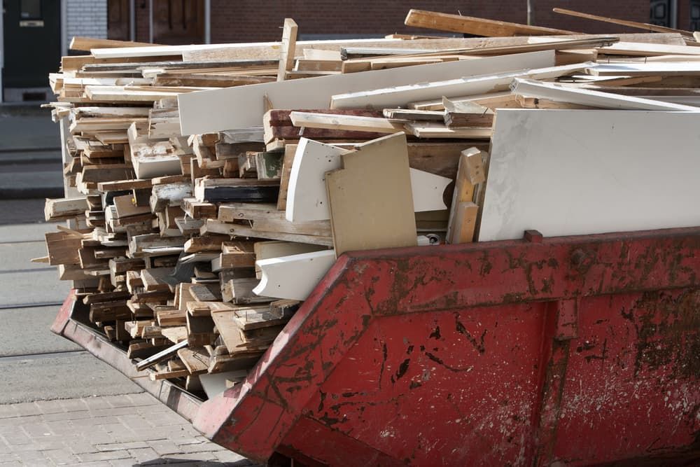 A Red Dumpster Filled With a Pile of Wood — Viking Skip Bin Recycling In Albion Park, NSW
