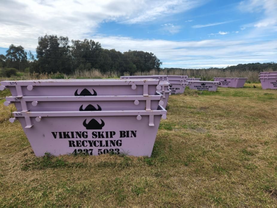 A Bunch of Purple Viking Skip Bins in a Field — Viking Skip Bin Recycling In Dunmore, NSW