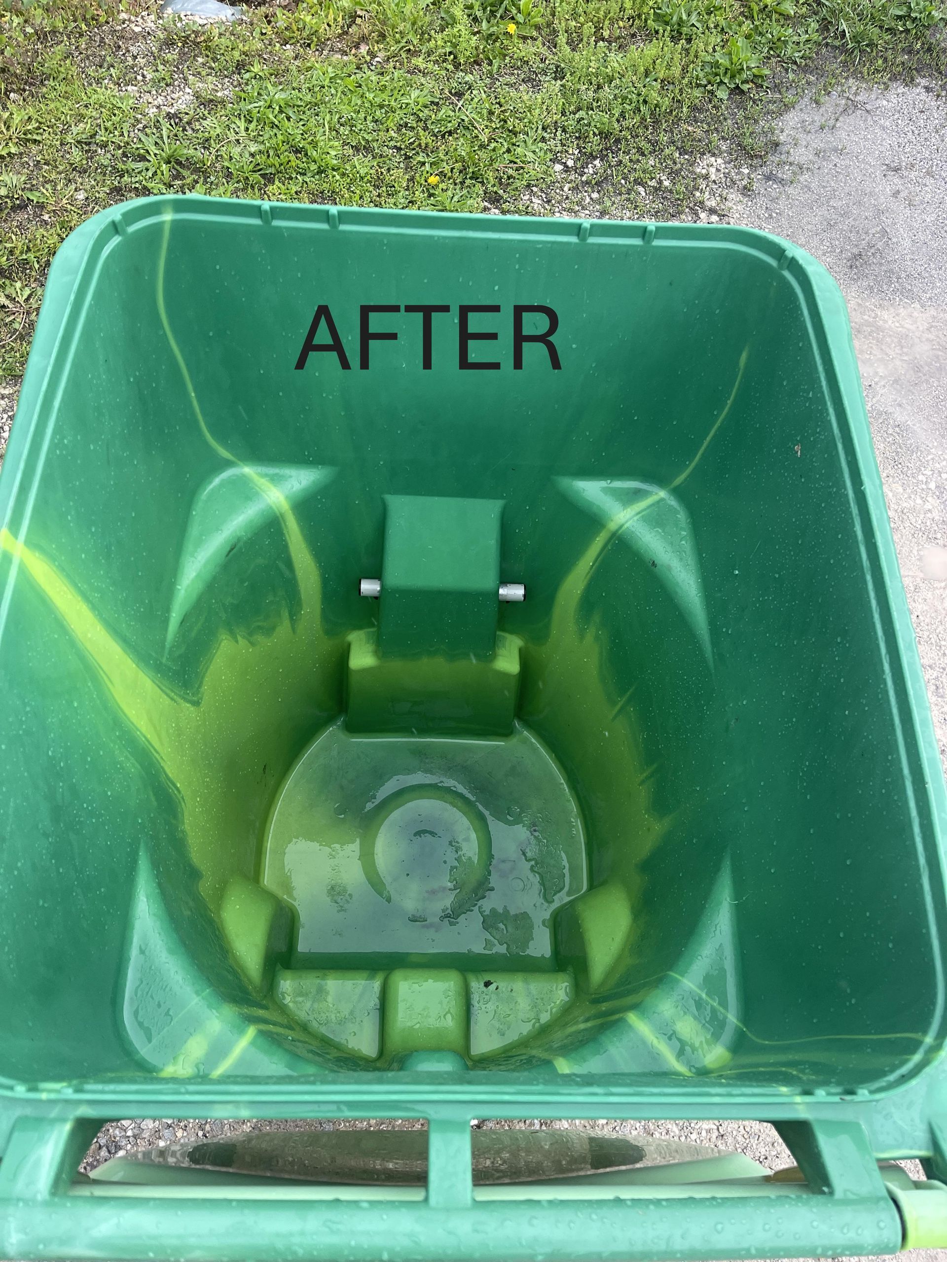 A person is holding a blue trash can on the sidewalk.