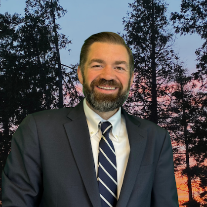 A man in a suit and tie is smiling for the camera.