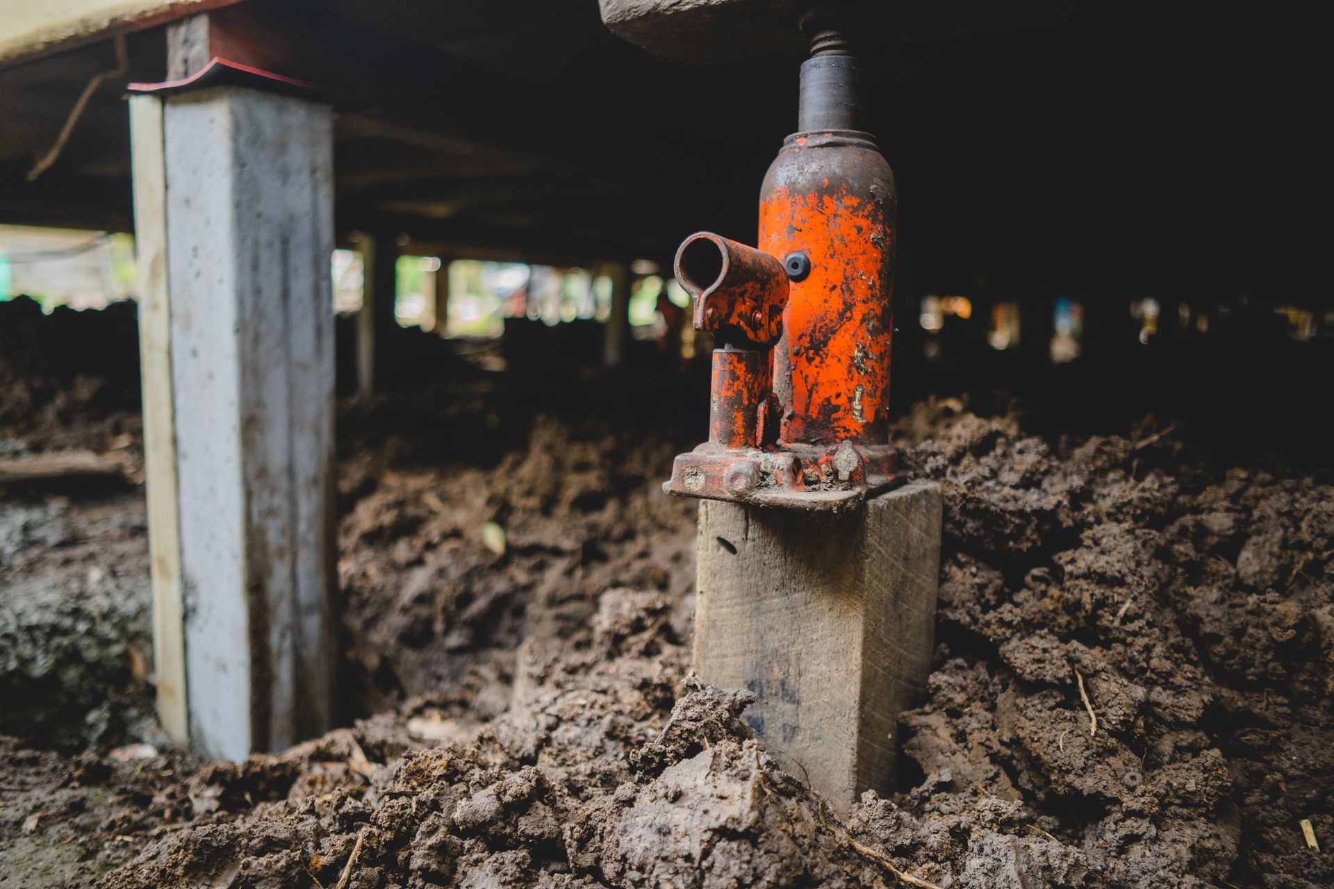 A jack under a house while repairing the foundations.