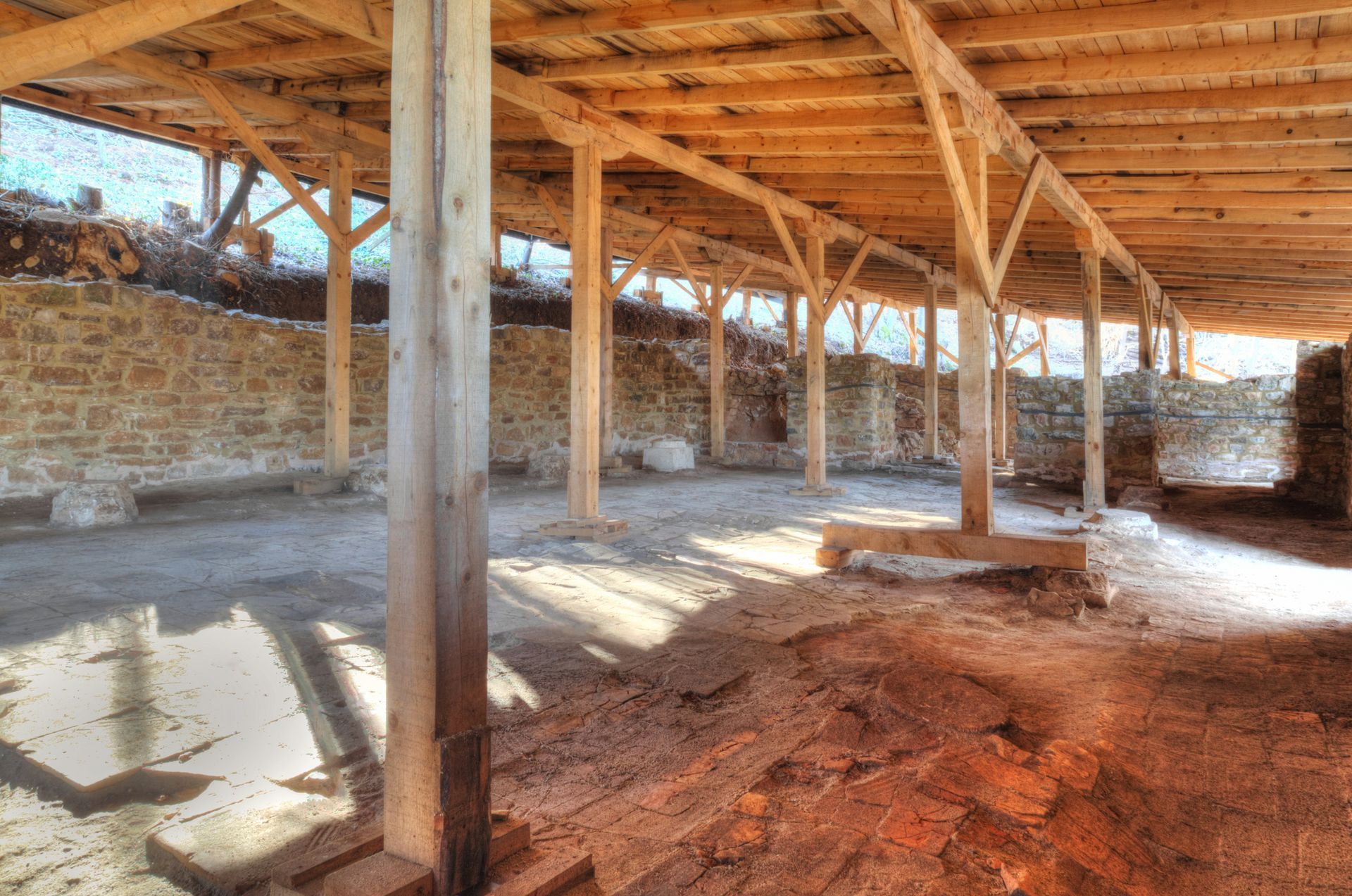Wooden structure with stone walls and sunlight streaming through.