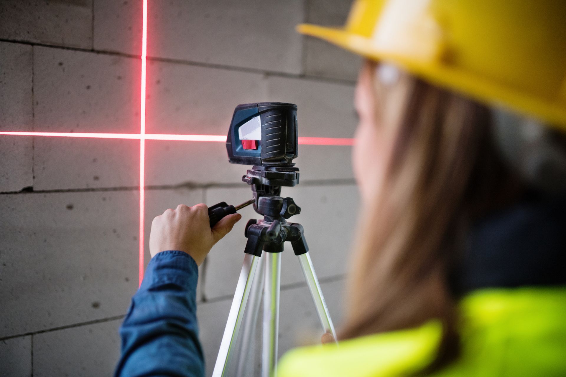 Young Woman Worker with Laser on the Building Site | Melbourne, Vic | Vip Reblocking & Underpinning