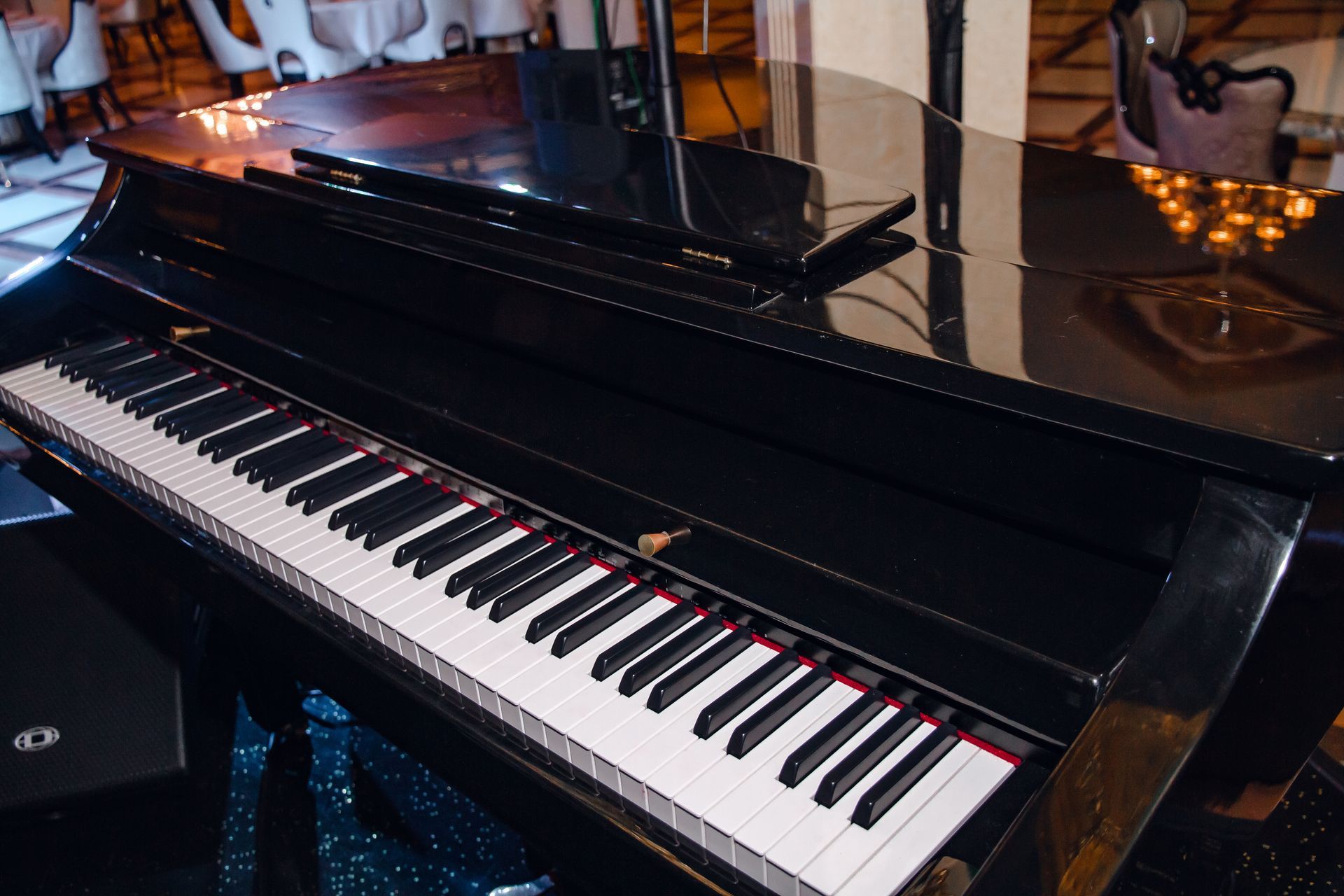 A black grand piano is sitting on a table in a room.