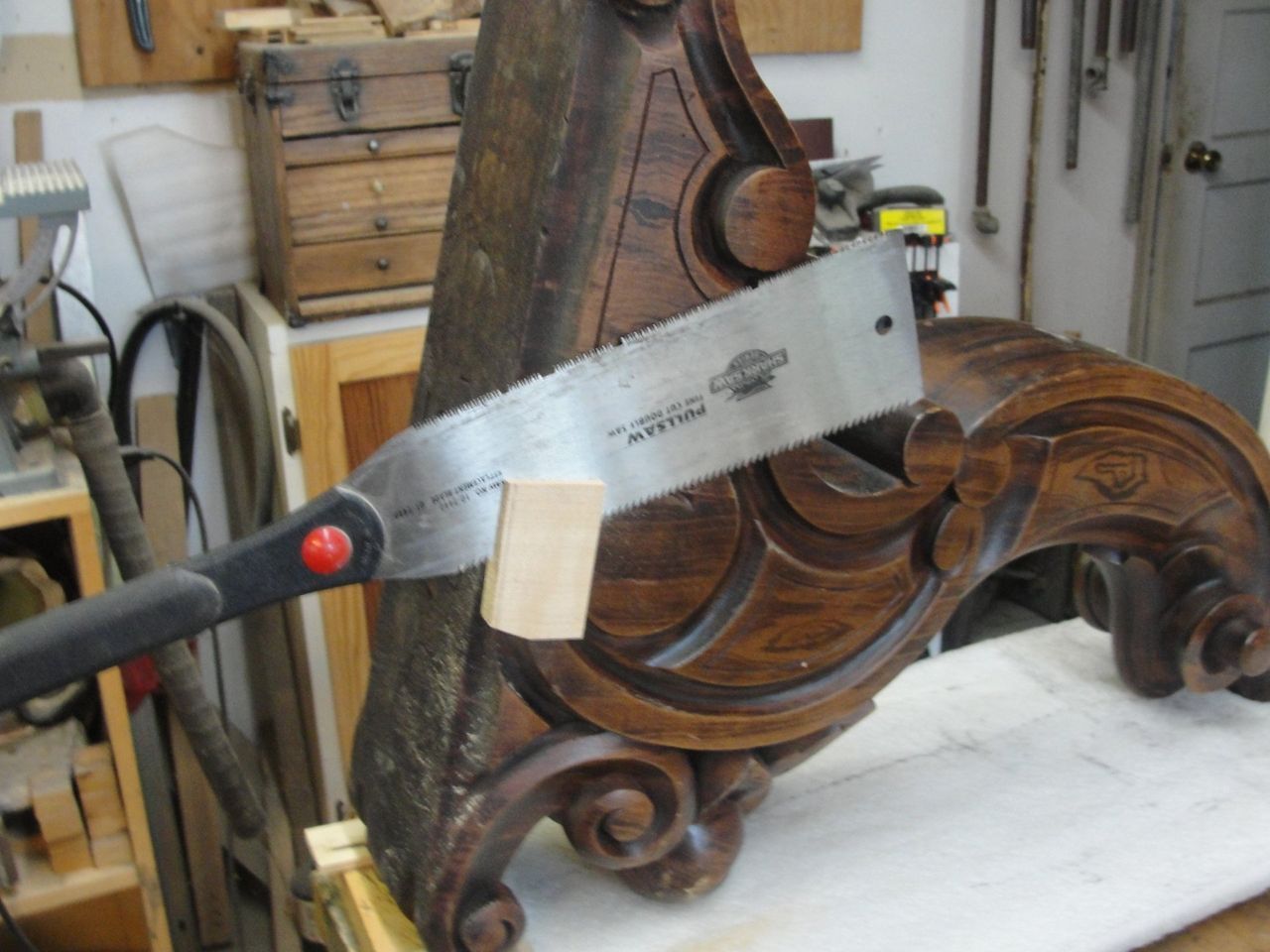 A saw is being used to cut a piece of wood