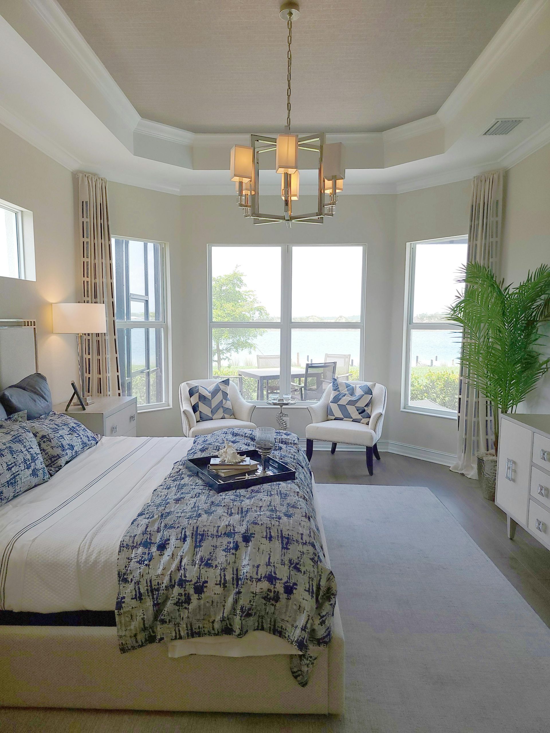 A bedroom with a large bed and lots of windows
