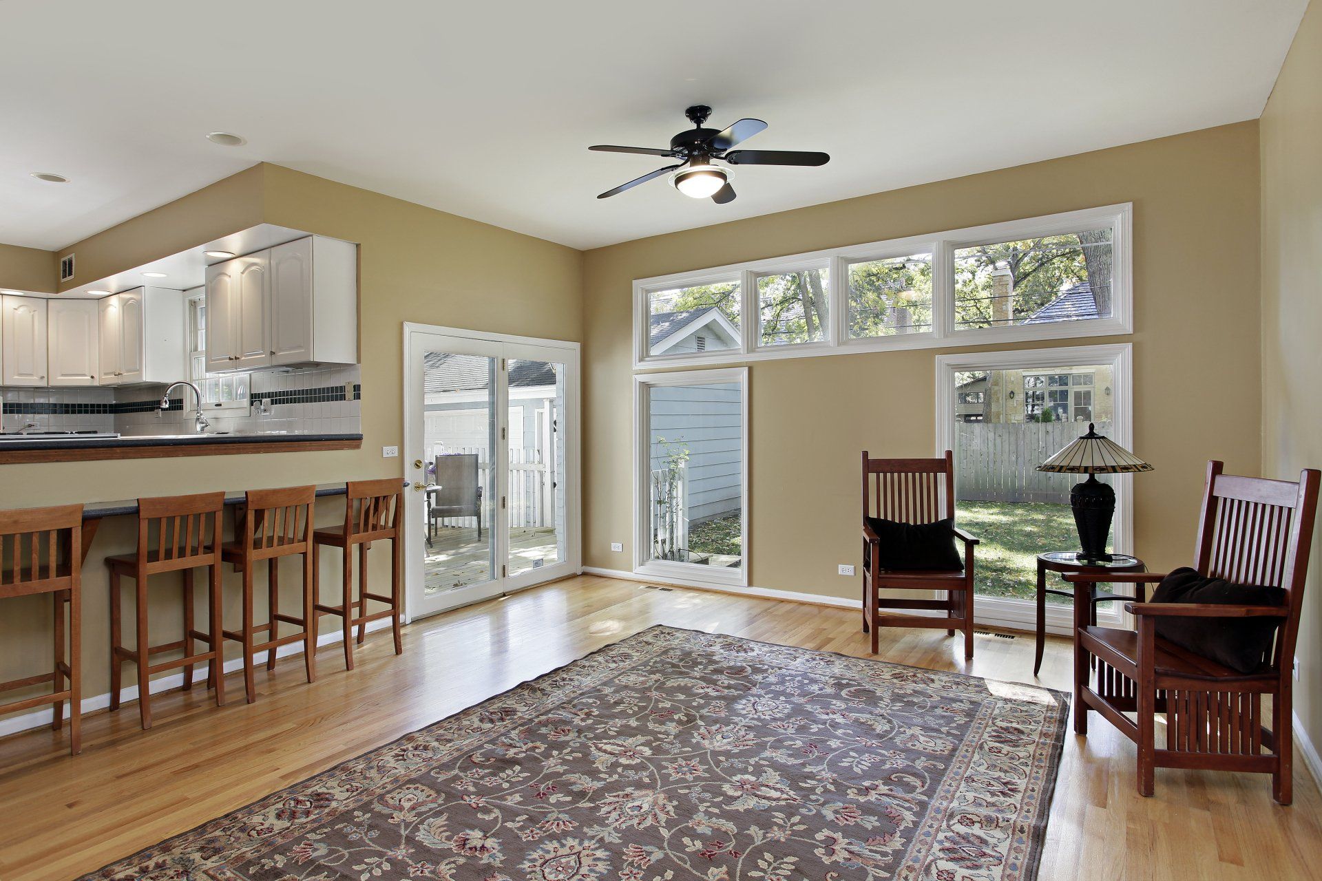 A living room with a rug and a ceiling fan