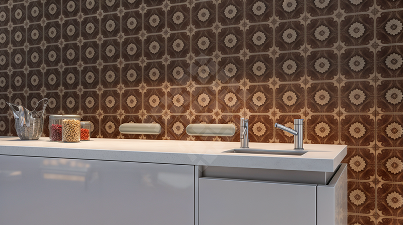 A kitchen counter with a sink and a patterned wall behind it.