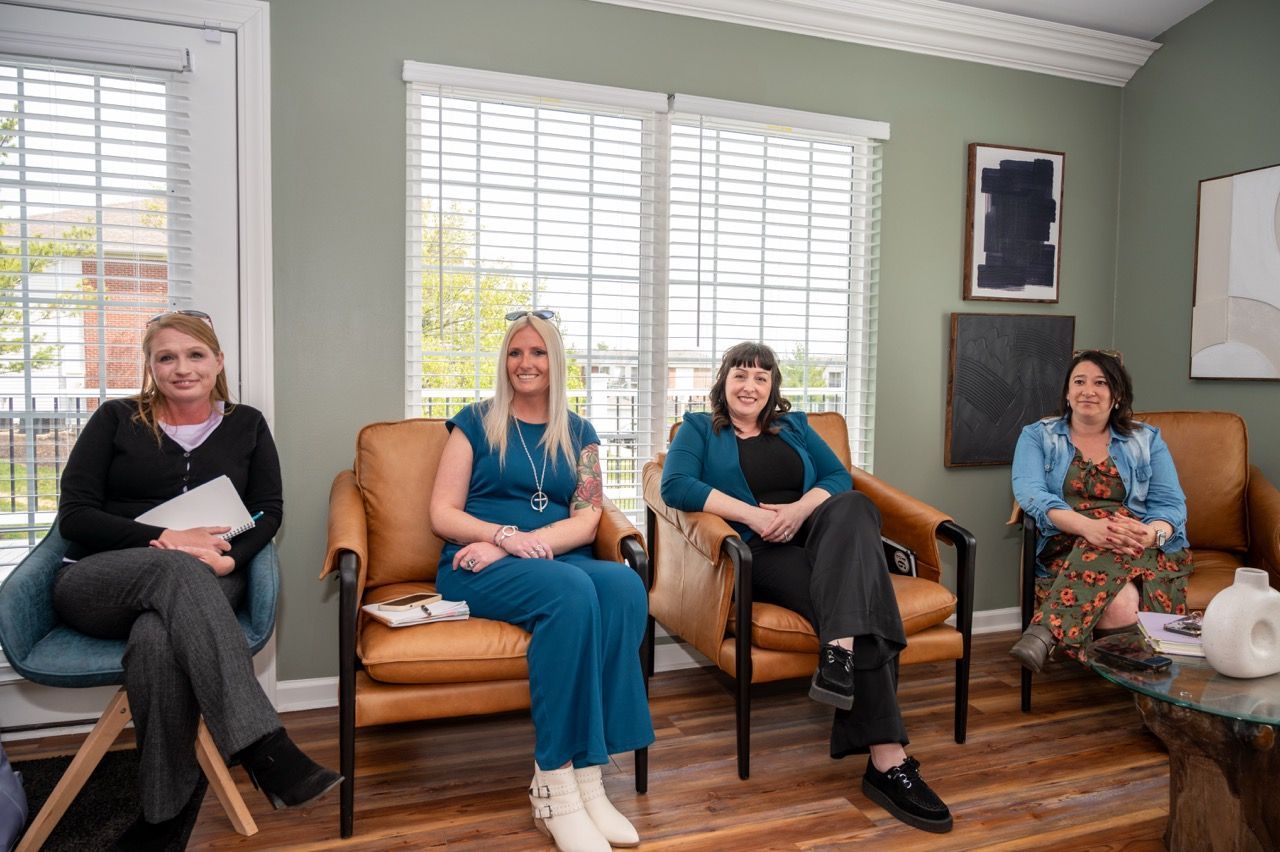 Four female team members from Bridgewater, Knollwood, and 860 sitting together in a lounge area during a company event.
