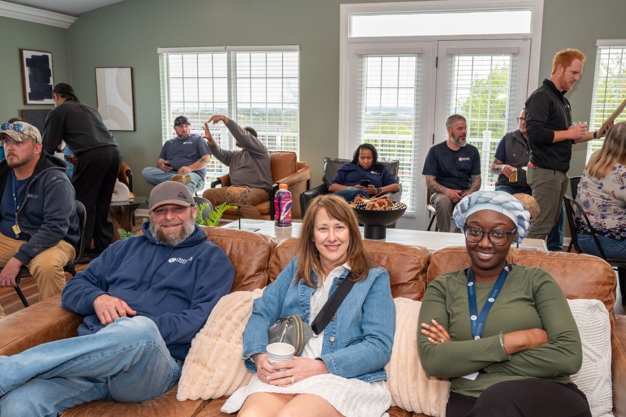 Residents and team members sitting together on couches during a community event.