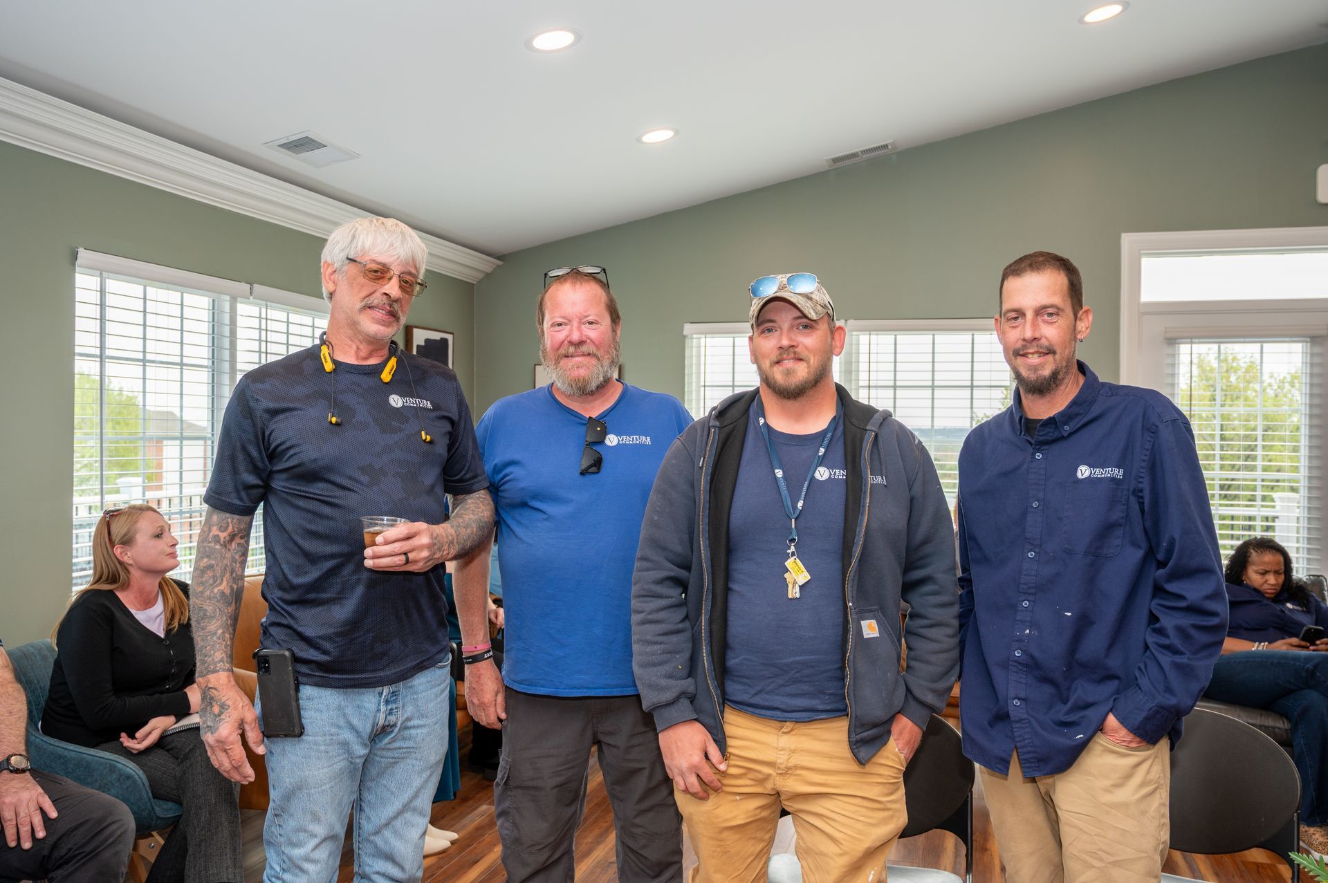 Group of maintenance staff standing together inside a clubhouse during an event.