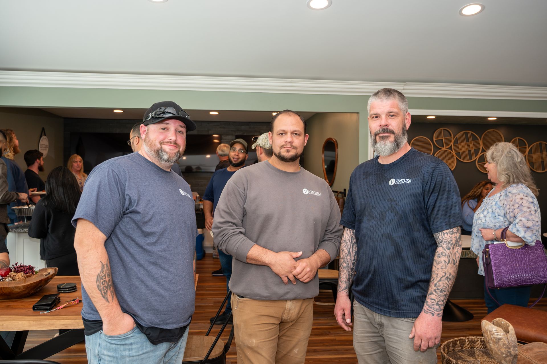 Three maintenance team members standing together and smiling at a company gathering.