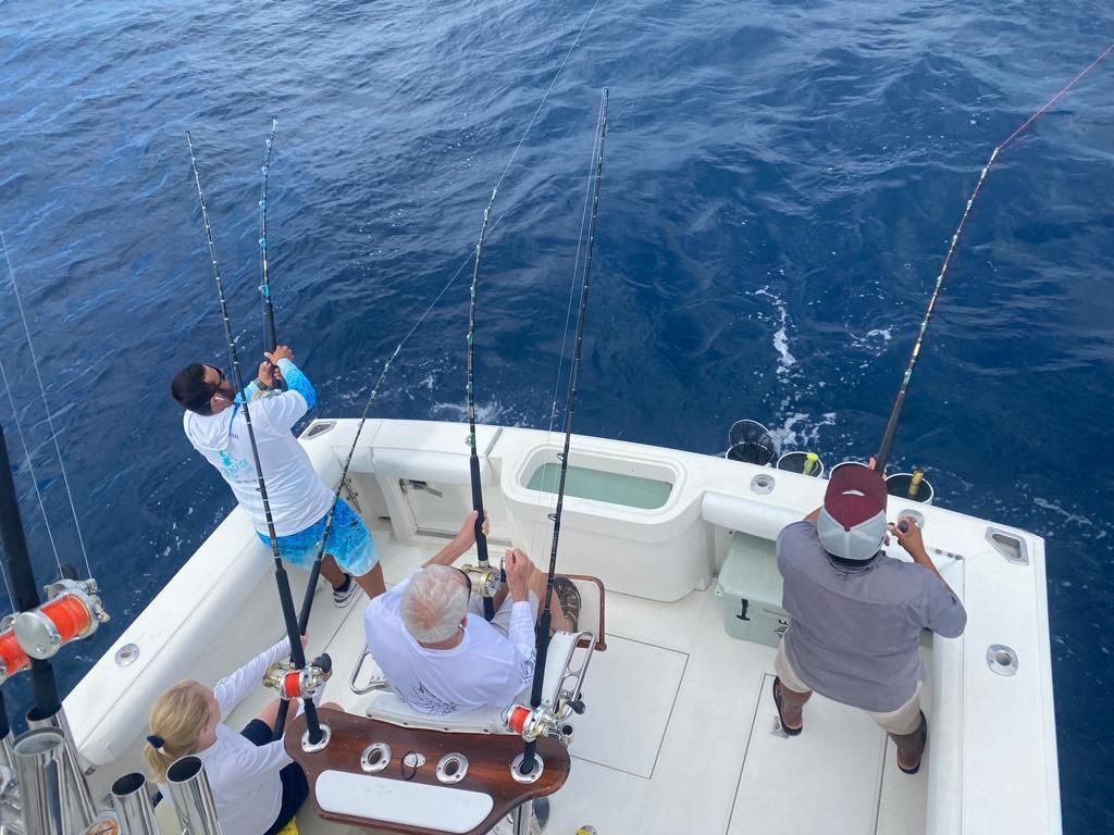 a group of people are fishing on a boat in the ocean .