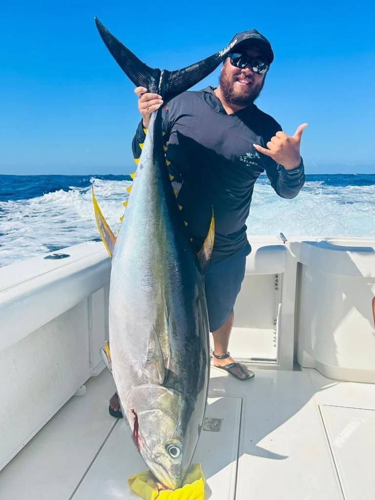 a man is holding a large fish on a boat .