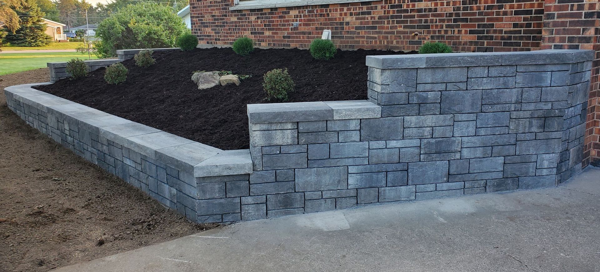 A brick wall with a planter in the middle of it