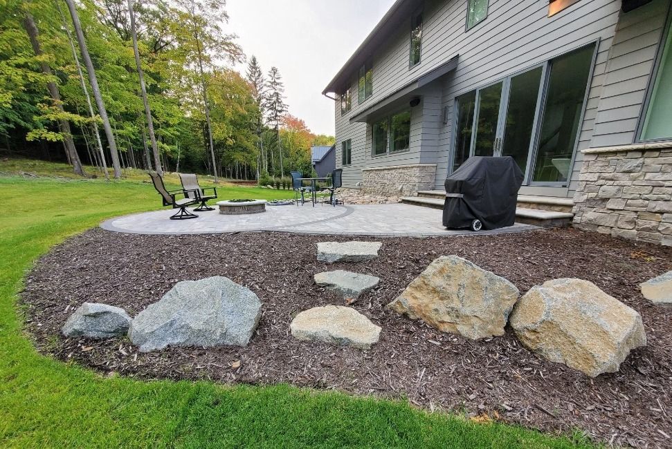 A large house with a patio and a fire pit in front of it.