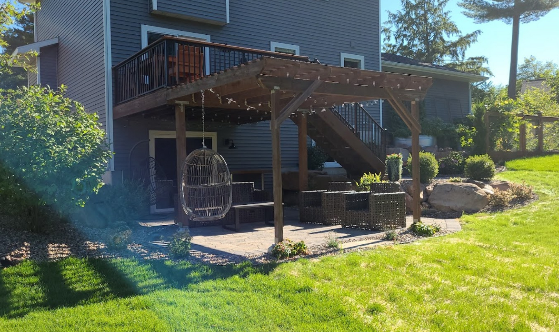 A house with a deck and a pergola in the backyard.