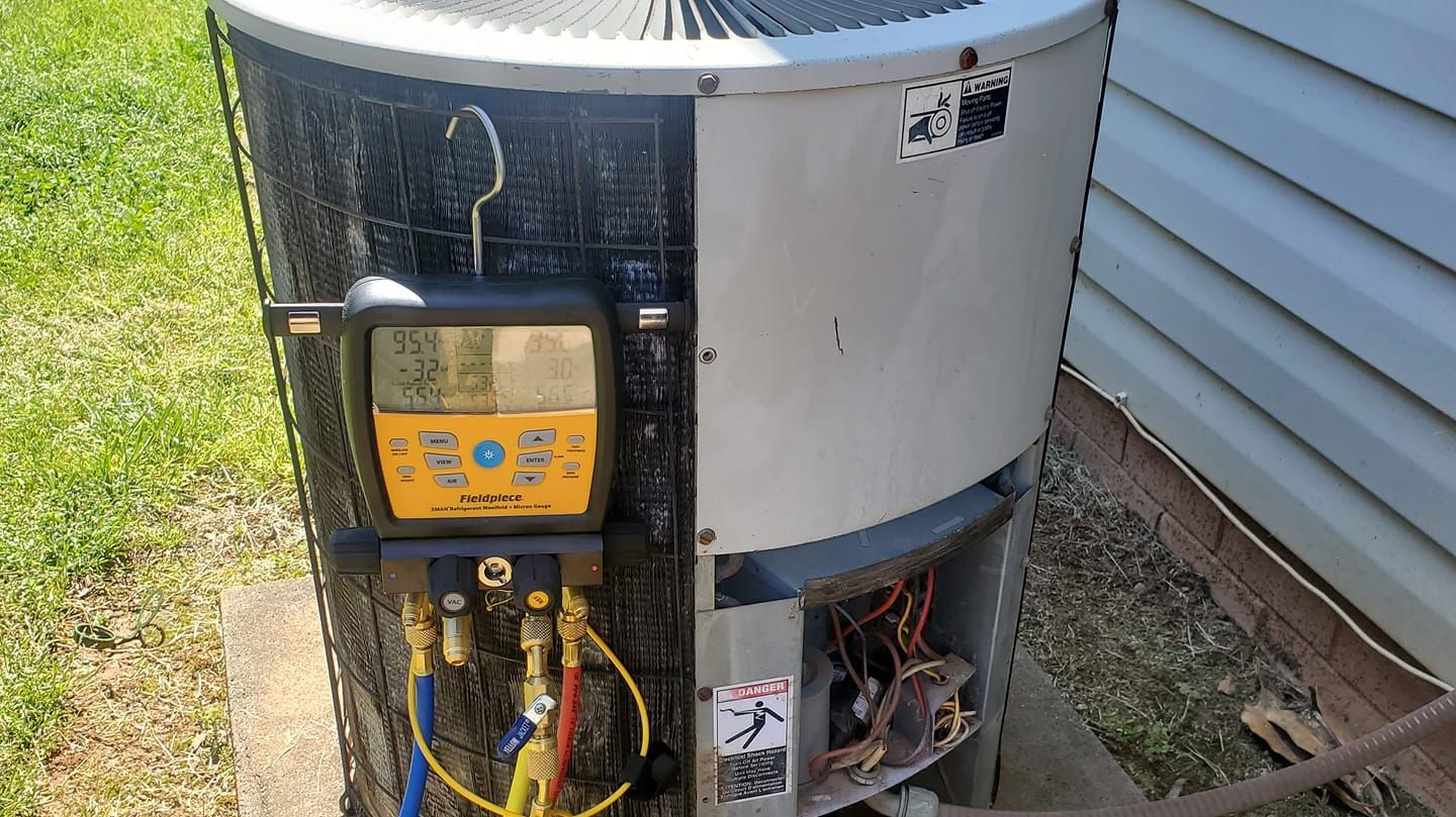 An air conditioner is being serviced by a technician.