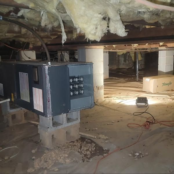 An electrical box is sitting in the corner of a basement.