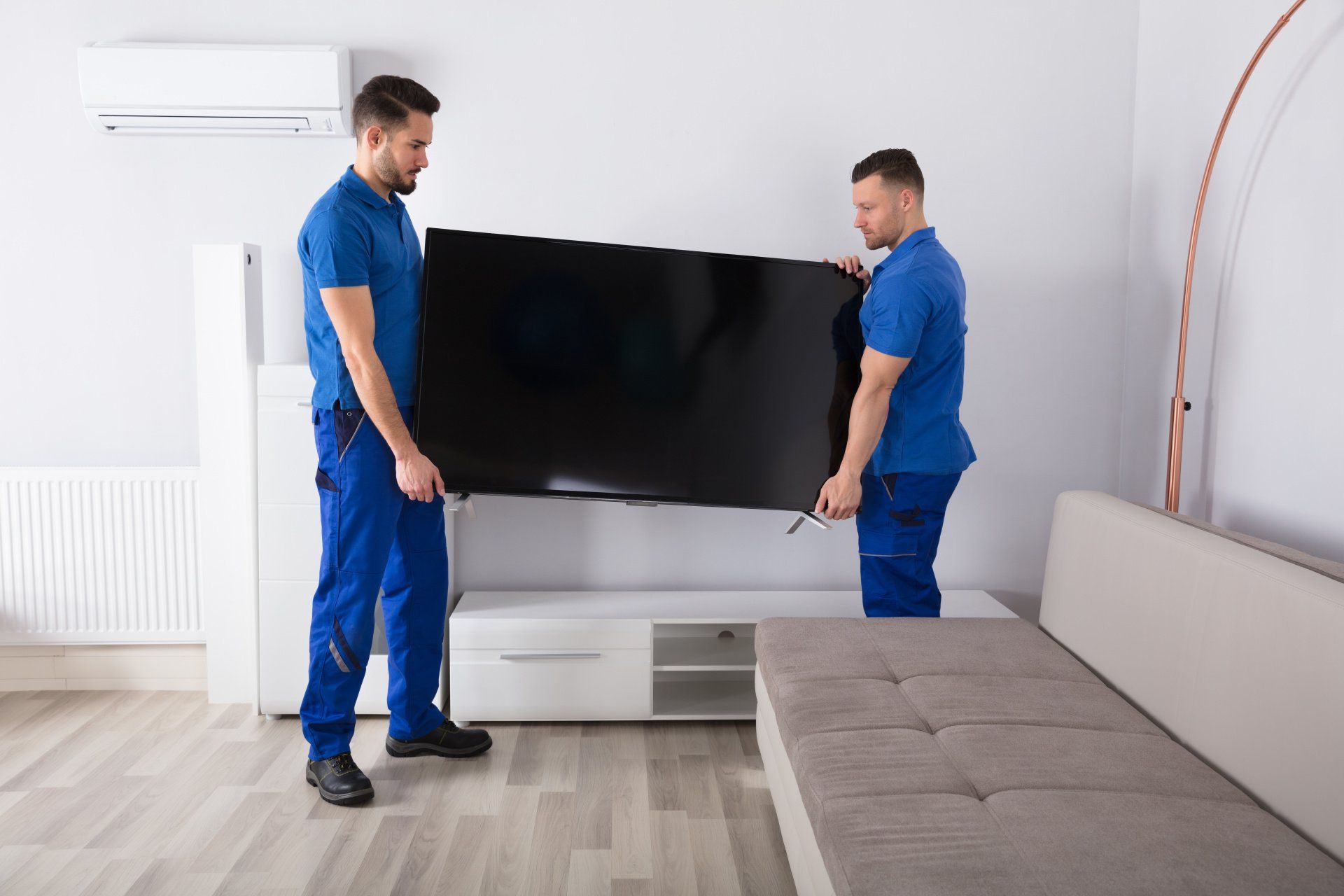 Movers carrying TV safely