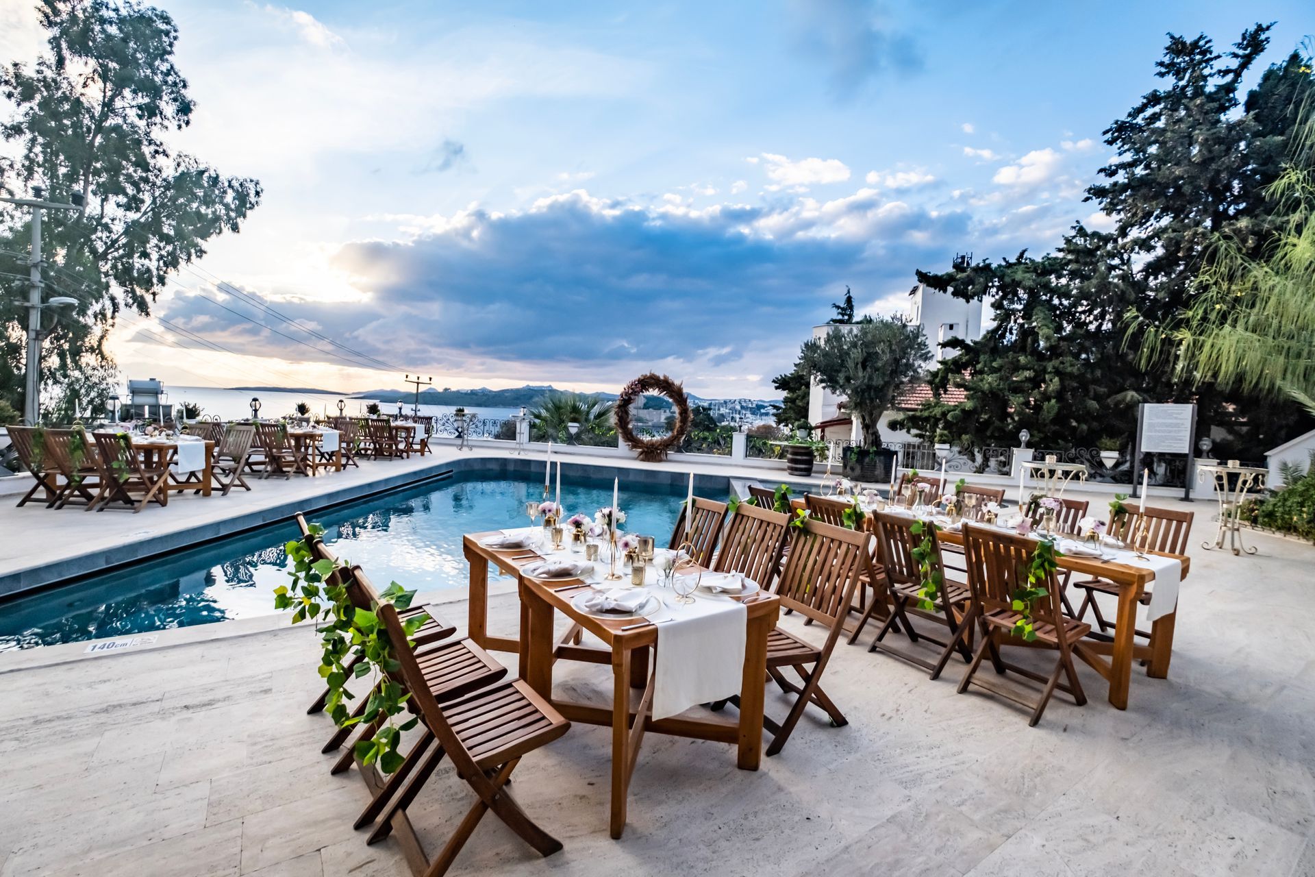 A table and chairs are set up in front of a swimming pool.