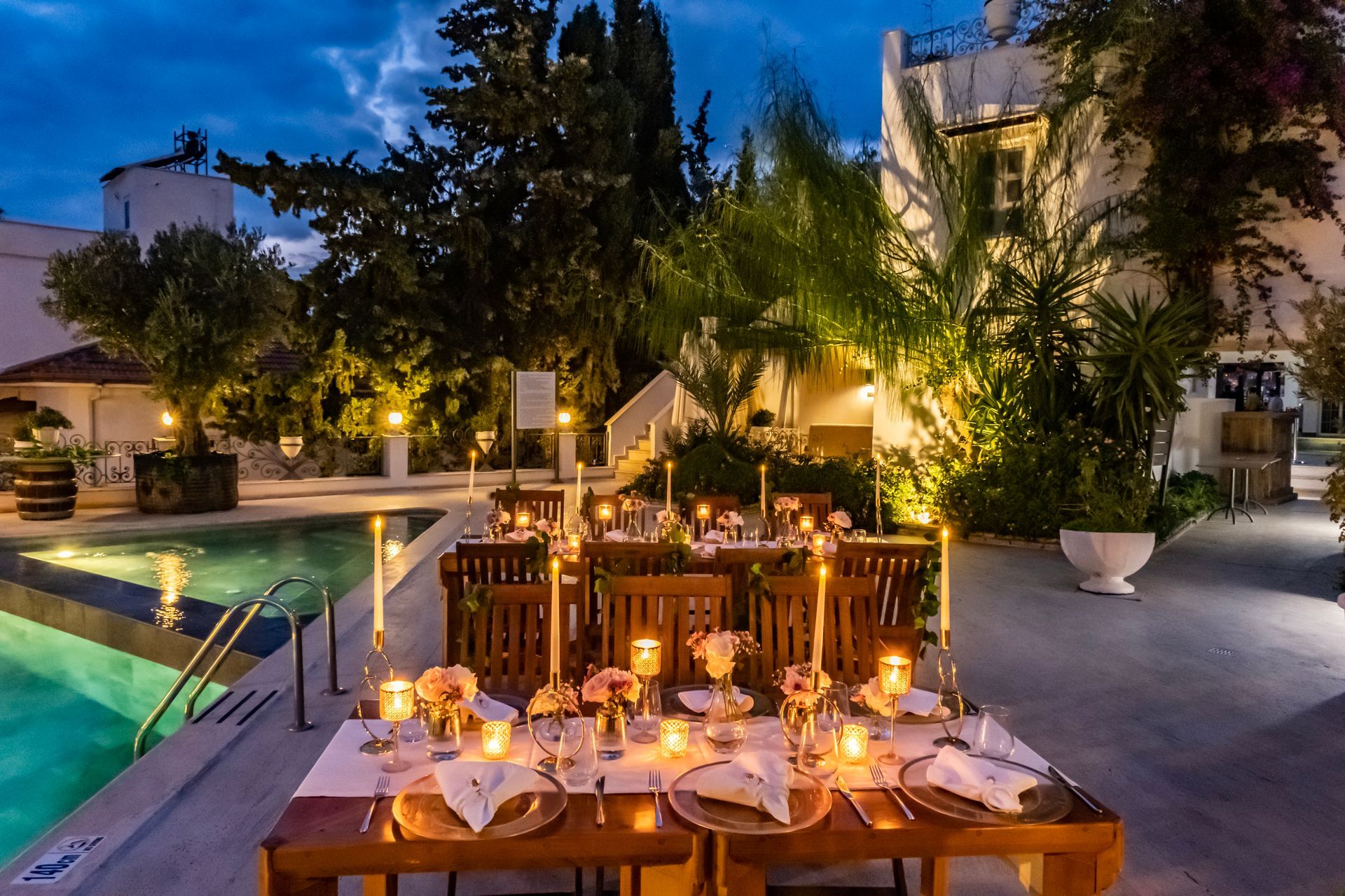 A table with candles on it in front of a swimming pool